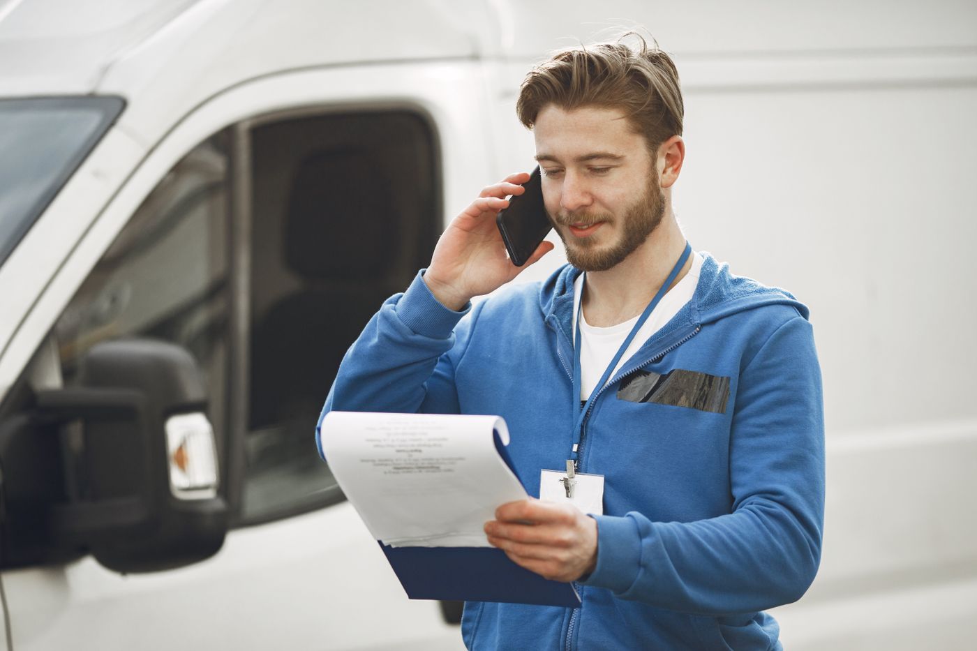 Artisan au téléphone devant sa camionnette